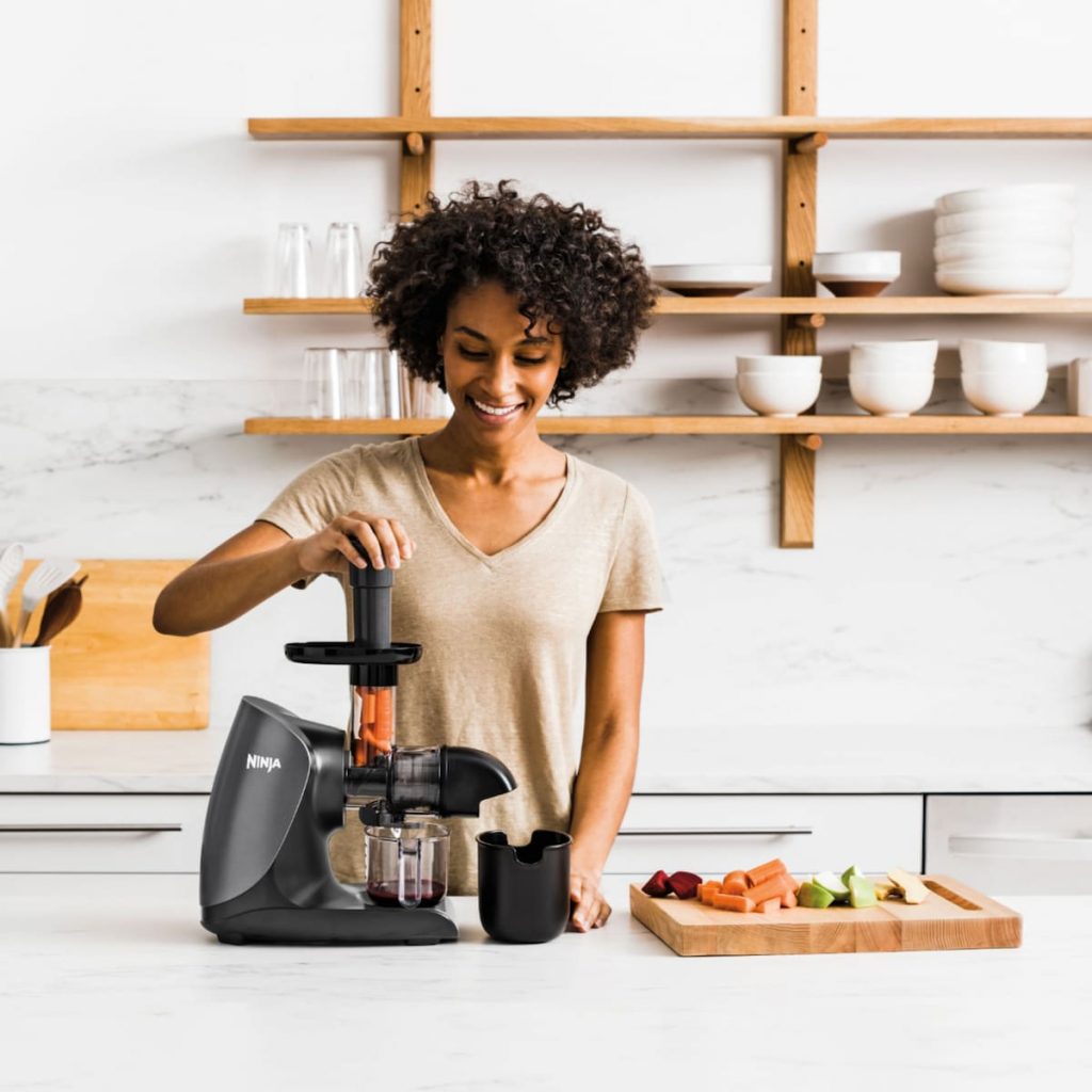 a black woman using juicer