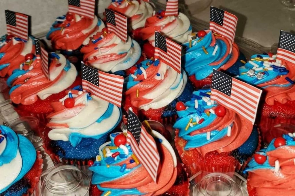 patriotic cupcakes with mini american flags at the top of it